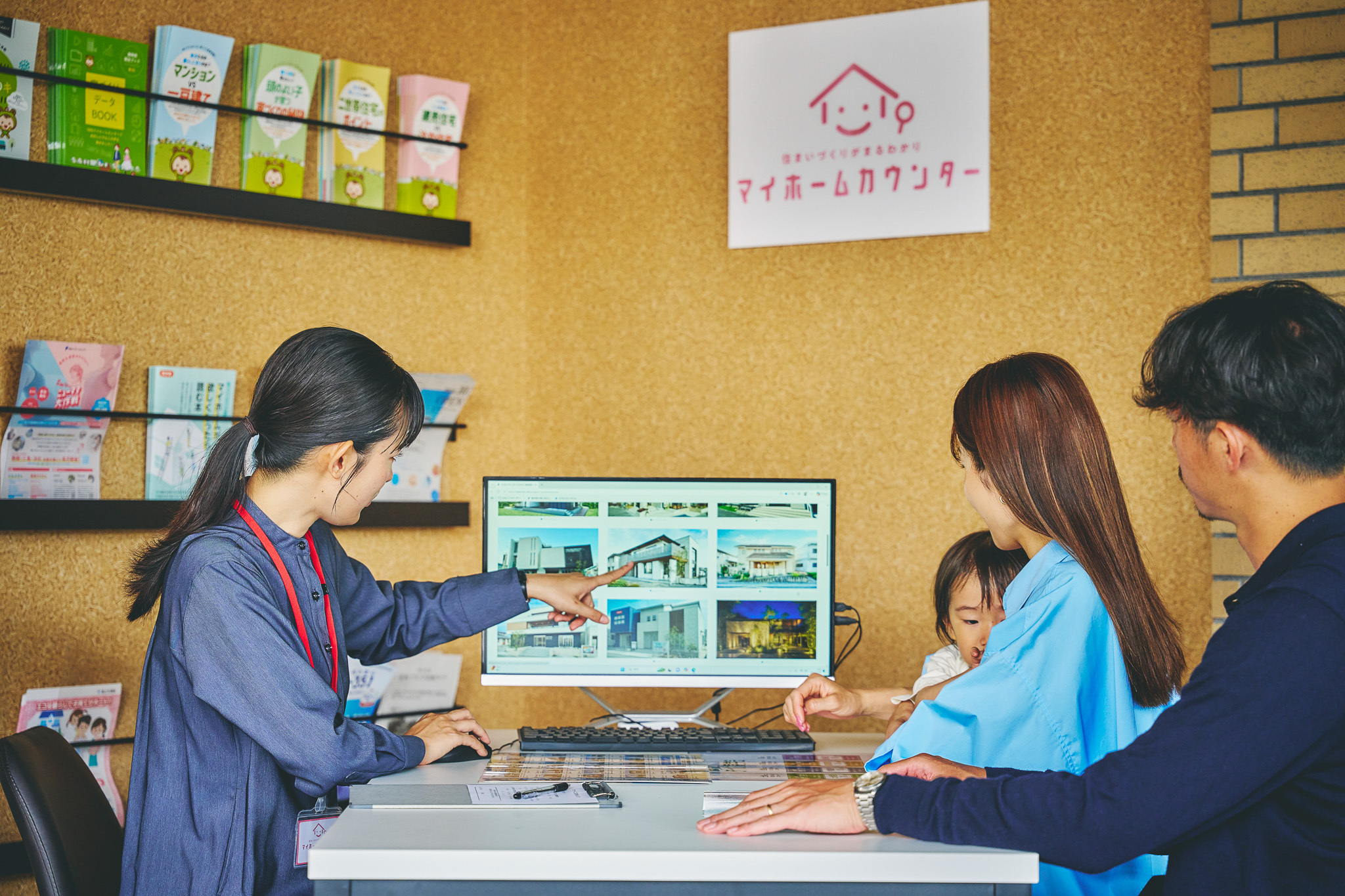 総合案内所でモニターを見ながら展示場の全体像を確認する家族