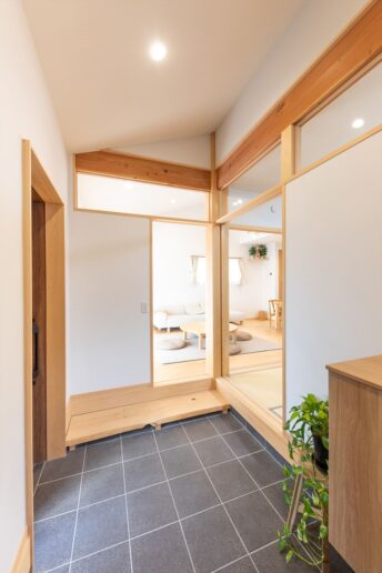 勾配天井が開放的な玄関土間。ご家族が来た時にベビーカーが置けるように広めに設けました。