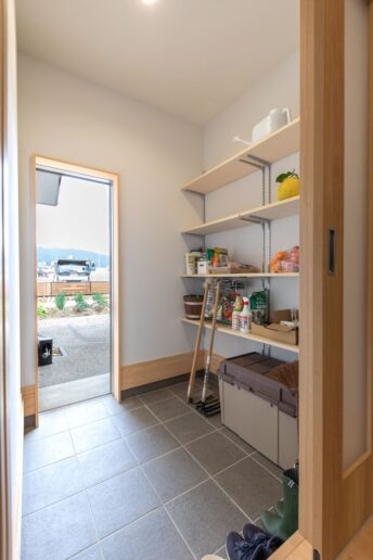 裏の畑へつながる土間には、家庭菜園で使うクワや肥料などを置いています。水回りへ直行できる配置なので、畑仕事で汚れても安心。