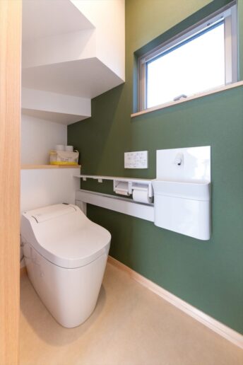 アクセントクロスがオシャレなトイレ。階段下を余すことなく活用しているので、トイレットペーパーなどのストックをたっぷり収納できます。