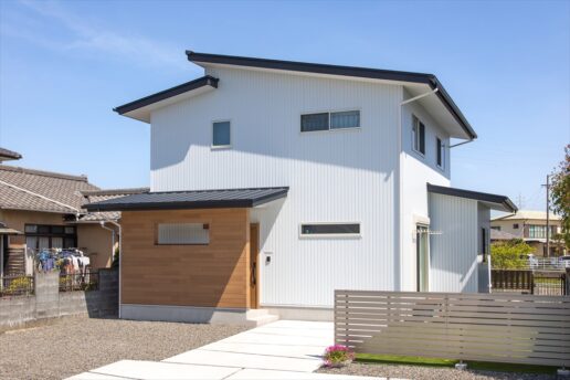 道路からの視線を遮るように玄関前に目隠しの壁をつくりました。白のガルバリウムに木目がよく映えています。