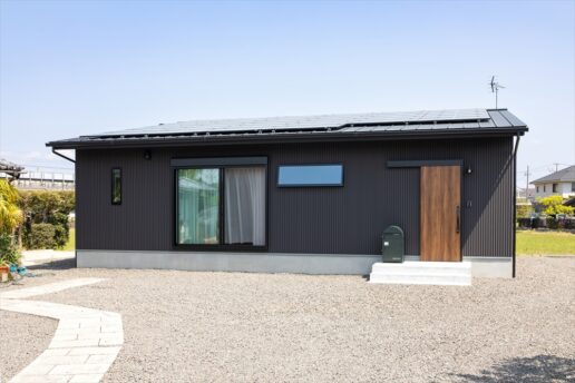 ギングロのガルバリウムに黒のサッシを合わせた男前な平屋。木目の玄関扉がメリハリを与えてくれます。