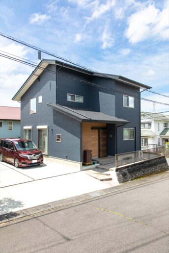 ネイビーの男前な外観。玄関まわりの木目調がアクセントになっています。