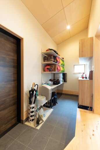 ホールを含めて４帖の広い土間空間。ゆとりがあるので、ご家族でお出かけする時も混雑しません。可動棚にはお外で使う洗車用品やお庭グッズの他、災害用のバッテリーなどを置いています。