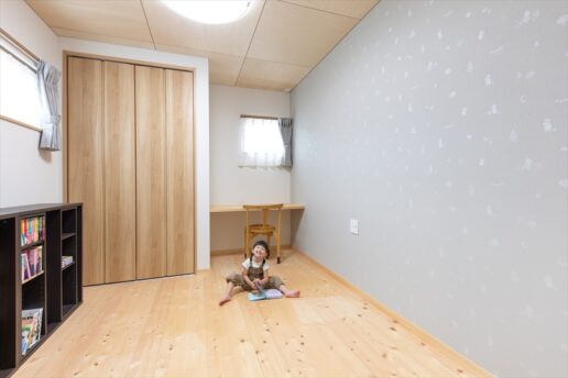 アクセントクロスが可愛らしい子ども室。勉強机の代わりにカウンターを造りつけました。