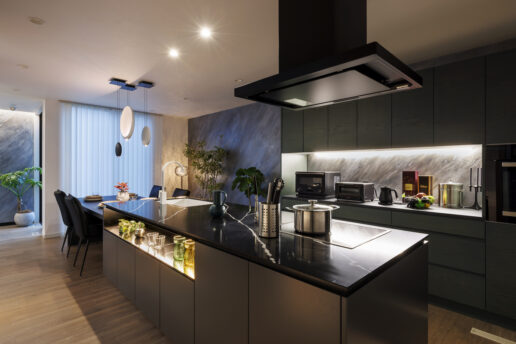 アイランドキッチンが堂々と佇むキッチン。カップボードの背面にもイタリア製漆喰ユーロスタッコを施した極上の空間。