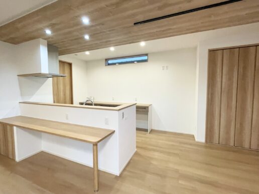 ナチュラルな色味のキッチンは、ダイニングテーブルを横並びで配置できるので、配膳や片付けがラクに。