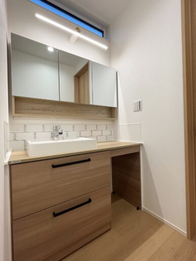 木のぬくもりを感じる洗面スペース。正面にアクセントでタイルを施工。