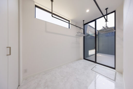 浴室→脱衣室→洗面室から連続するランドリールーム。室内干しの後、そのままクローゼットに収納できます。ここからシームレスにつながるウッドデッキは縁側のような空間で、猫が日向ぼっこを楽しんでいます。塀を高くしたので脱走される心配もありません。