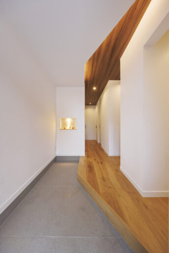 二世帯共用の玄関。奥に伸びるように土間を配置し、家族が並んで靴を履けるように設計しました。