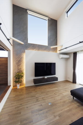 床から天井までダイナミックに施工したユーロスタッコ(イタリア漆喰)。テレビの背面にもうひとつ壁をつくり、アンシンメトリーなデザインに。壁の間に施した間接照明により、ユーロスタッコの表情がより立体的に楽しめます。