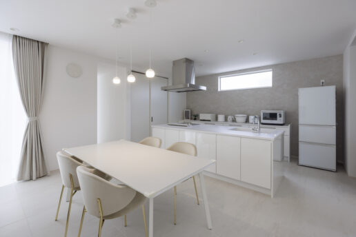 白いフロアタイルに合わせて、壁も天井もアイランドキッチン、カップボード、ダイニングテーブルセットもすべて白で統一しました