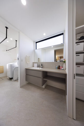 浴室・脱衣室・洗面室・ランドリーと一直線に並ぶ「神動線」を実現しました。洗面室は広くとり、鏡も大きめに。ランドリールームには「乾太くん」と靴も洗えるスロップシンクを設置しました。「もう、本当に家事がラクになりました」と話す奥さまの言葉に実感がこもっています。