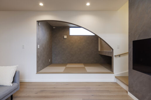 リビングの一角に設けた小上がりの和室。垂れ壁をアーチ形状に切り取って、モダンな空間に。子どもたちがここで遊んでいる様子がキッチンから目が届くので安心です。ゲストが泊まりに来たときは、ロールカーテンで仕切ることもできます。
