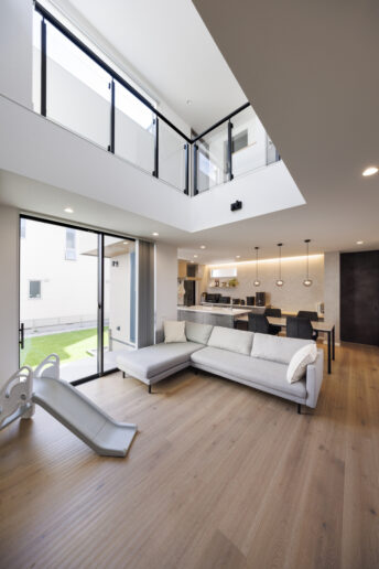 大きな開口部と吹き抜けから光が注ぐ開放感あふれるリビング。凹凸のある床は『nattoku住宅』オリジナルの無垢フローリングで、足裏に心地よさが伝わってきます。
