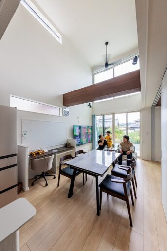 両隣を家に挟まれた縦長の土地。
光は入らないだろうと諦めていたご夫妻に、「窓の大きさや配置を工夫すれば、しっかり光は入りますよ」と営業担当の榛葉。
完成したダイニングには、大きな吹き抜けがあり、壁一面の大きな窓からたっぷりの光が降り注ぎます。
奥さまが高校時代から憧れていた、“光が入る吹き抜けのある家”がついに実現。