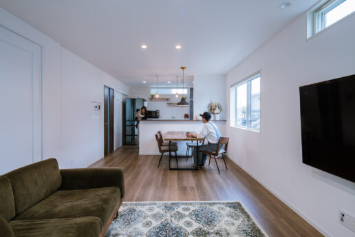 白をベースに色数を抑えたスマートな内装に。床板を利用したダイニングテーブルとキッチンの飾り棚は、部屋のイメージに合わせてご主人が作ったもの。