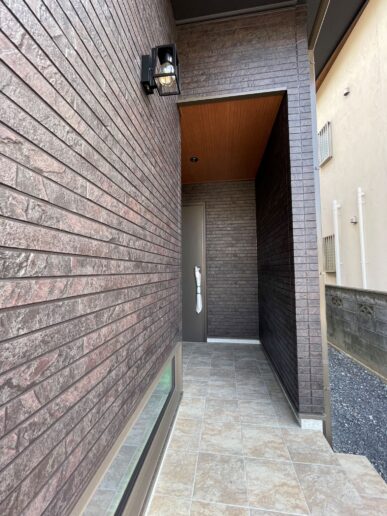 重厚な外壁に包まれた、奥行きのある玄関ポーチ。
光と素材感がつくる、帰るたびに気分が上がるアプローチ。