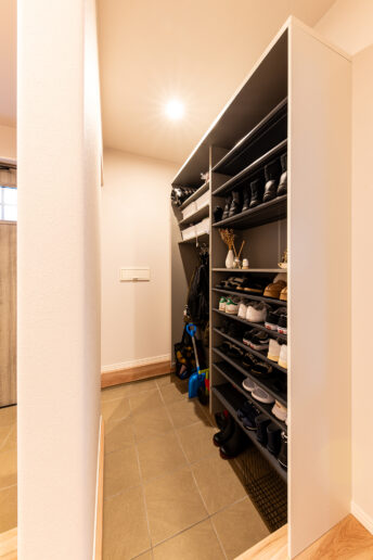 玄関の一角に作られたシューズクロークには、上着も掛けられるハンガーバーも備えている。