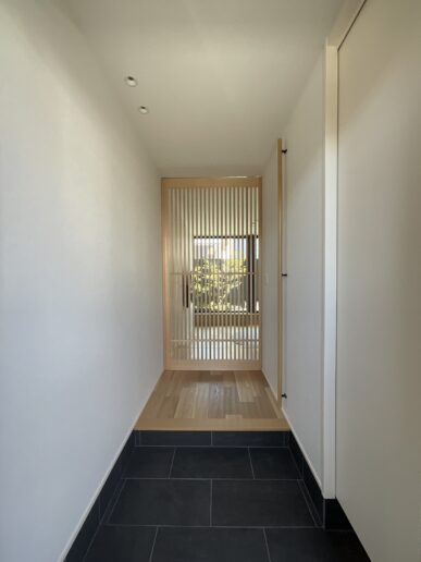 格子建具を採用し、和の風合いを感じられる玄関としました。
格子越しに見える庭の緑が空間に彩りを添え、四季を身近に感じながら過ごせます。